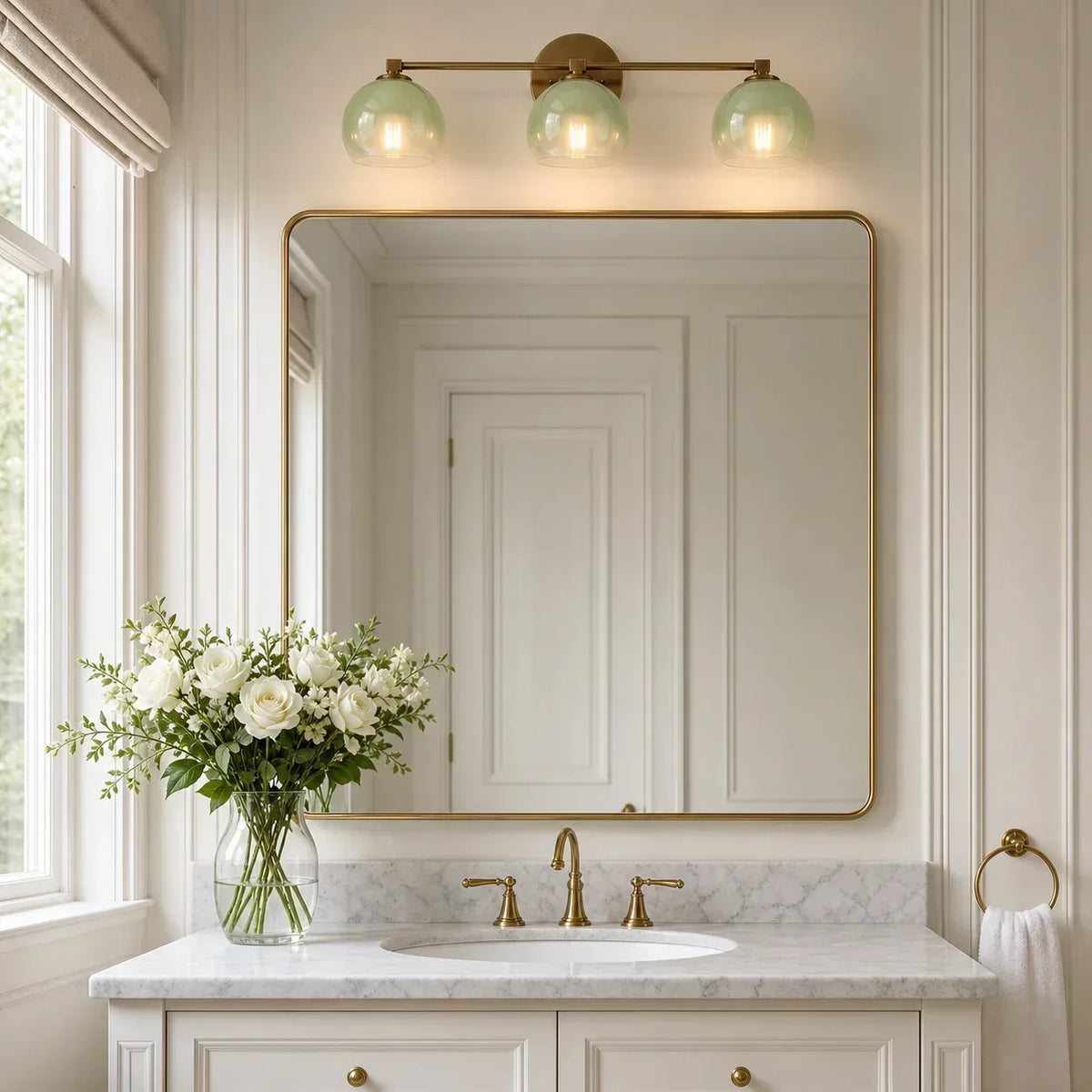 Three-light antique brass bathroom wall light above a wide vanity mirror